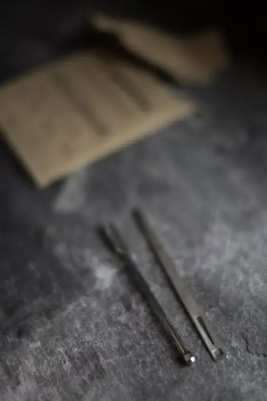Two metal tools on a textured dark surface