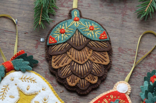 Decorative Christmas ornaments on a wooden surface with greenery.