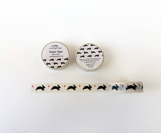 Two small round containers of washi tape with a white label printed with black rabbit silhouettes, shown above a matching strip of washi tape laid horizontally on a white background.