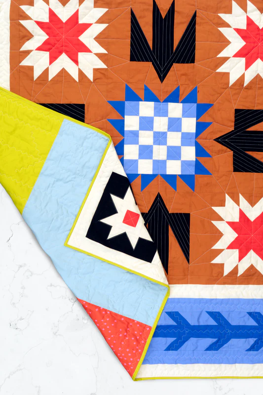 Colorful quilt with geometric patterns on a white background