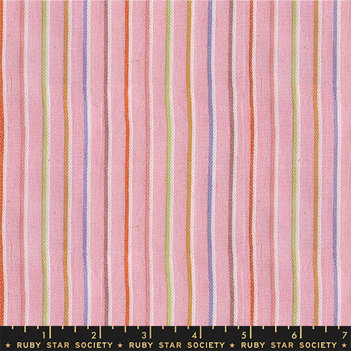 Pink striped fabric with vertical stripes in orange, purple, green, and white, shown with a Ruby Star Society ruler at the bottom for scale.