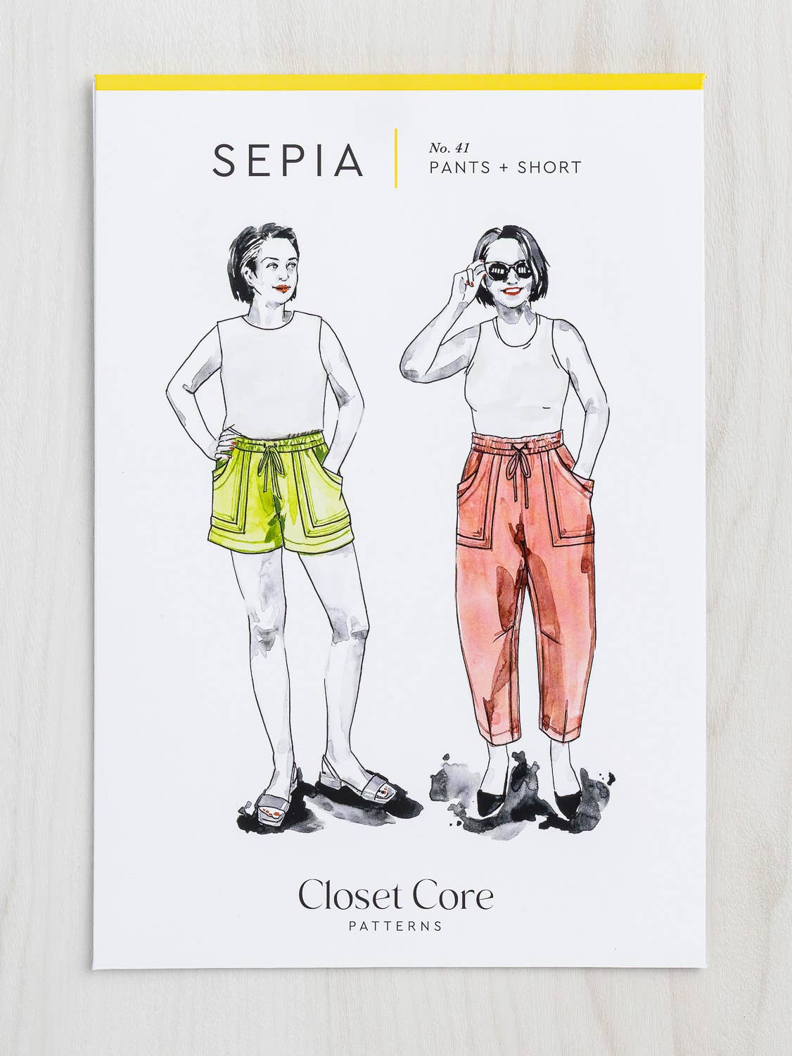 Sewing pattern cover for pants and shorts with illustrations of a woman wearing the garment on a white background.